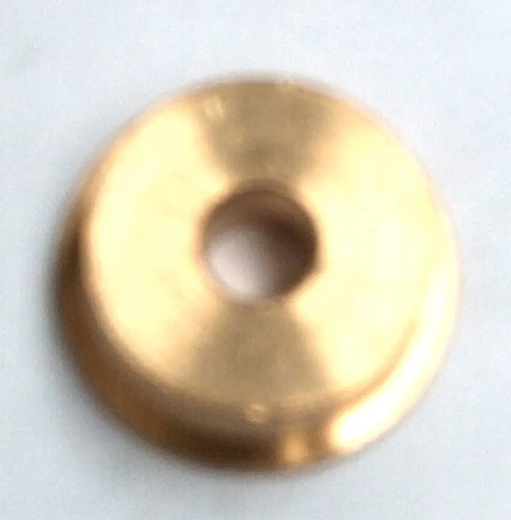 Goldfarbener, runder Metallring mit einem zentralen Loch, möglicherweise Teil eines gasbetriebene Geräts von Daikin.